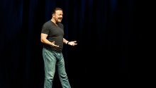 Ricky Gervais performing on stage